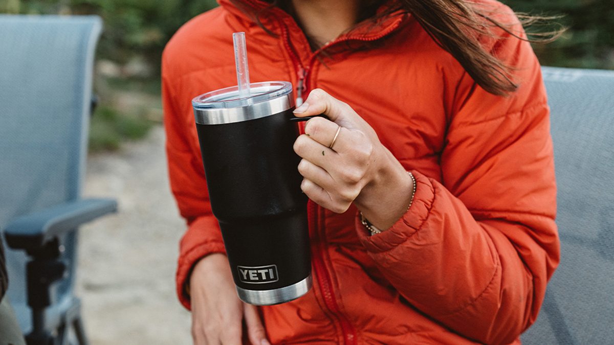 A person holding a black and silver cup