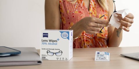 A woman holding glasses and a box of wipes