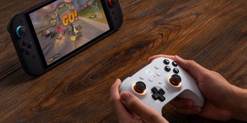 Image showing a person holding 8Bitdo's Ultimate 2 controller in white.