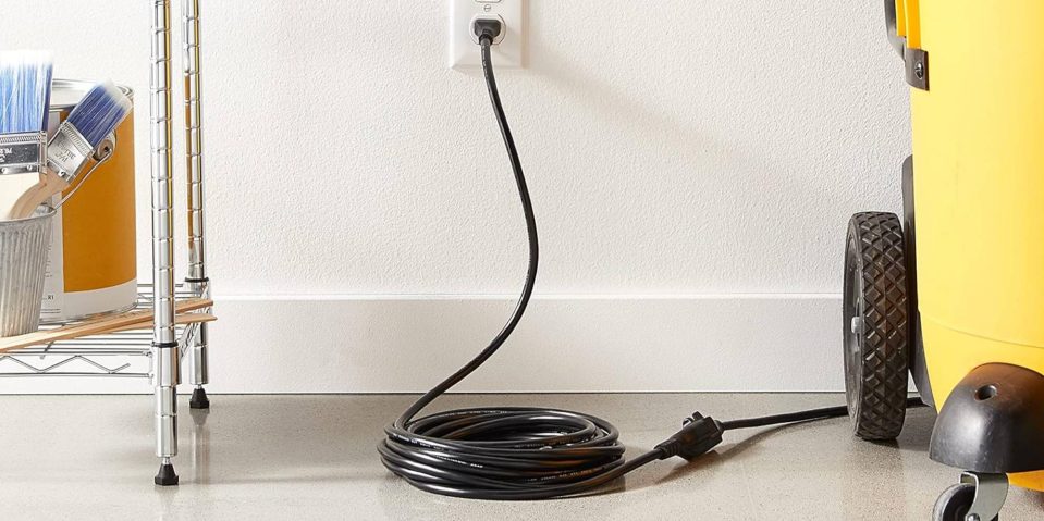 A black cord plugged into a wall outlet