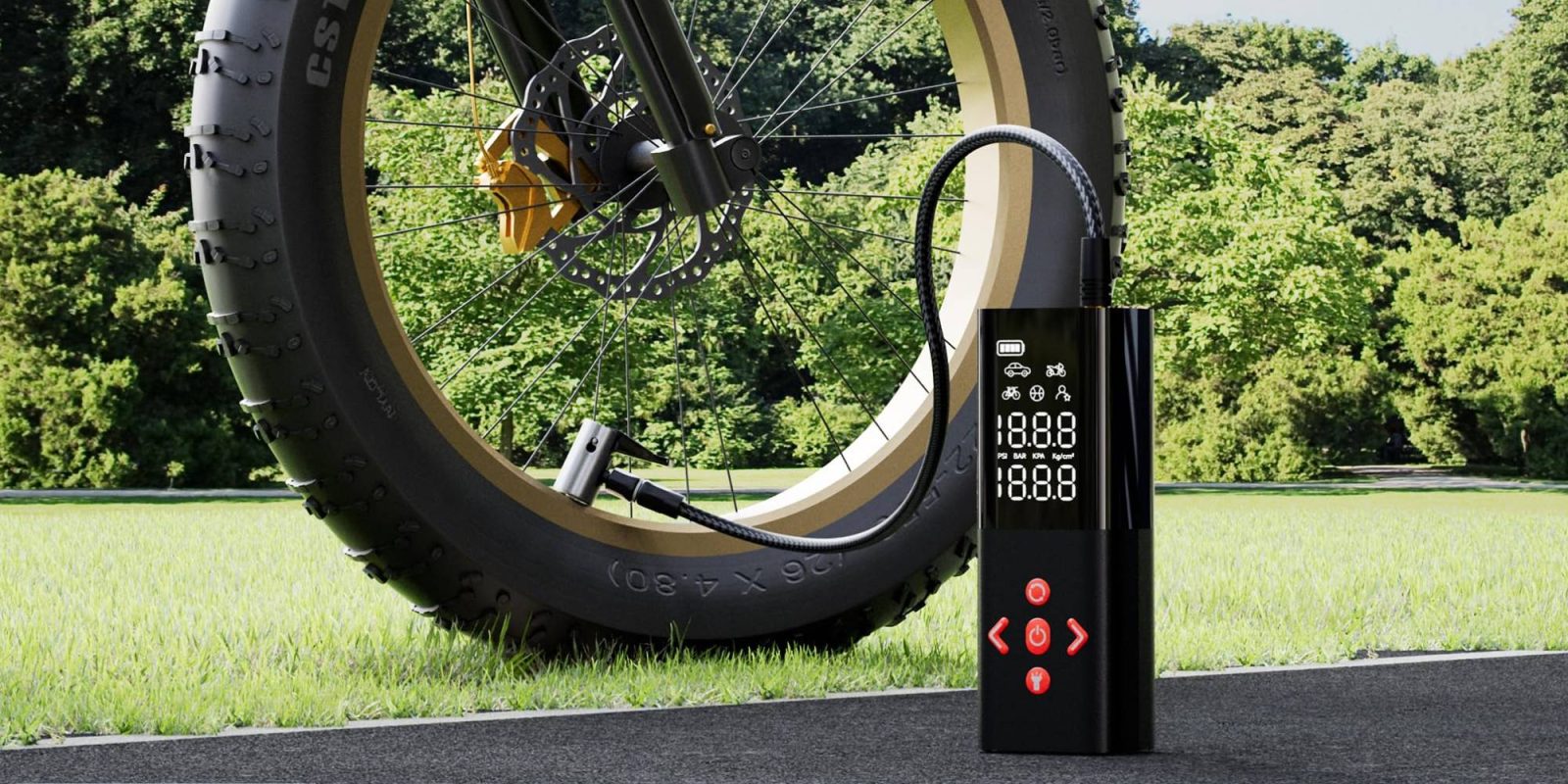 A black device with a digital screen next to a tire