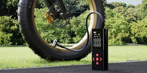 A black device with a digital screen next to a tire