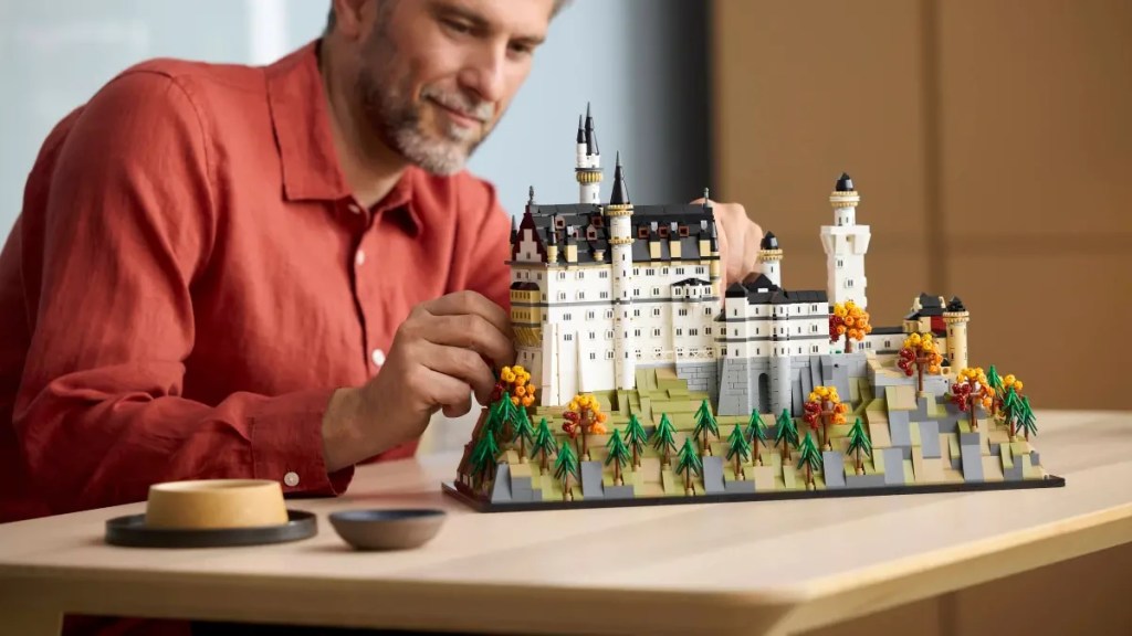 A man sitting at a table with a model of a castle