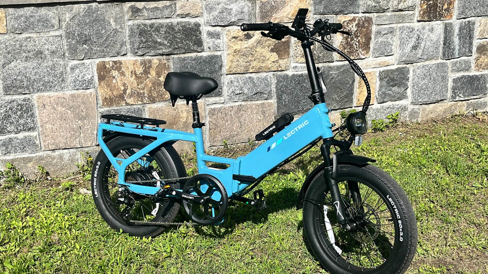 A blue bike next to a stone wall