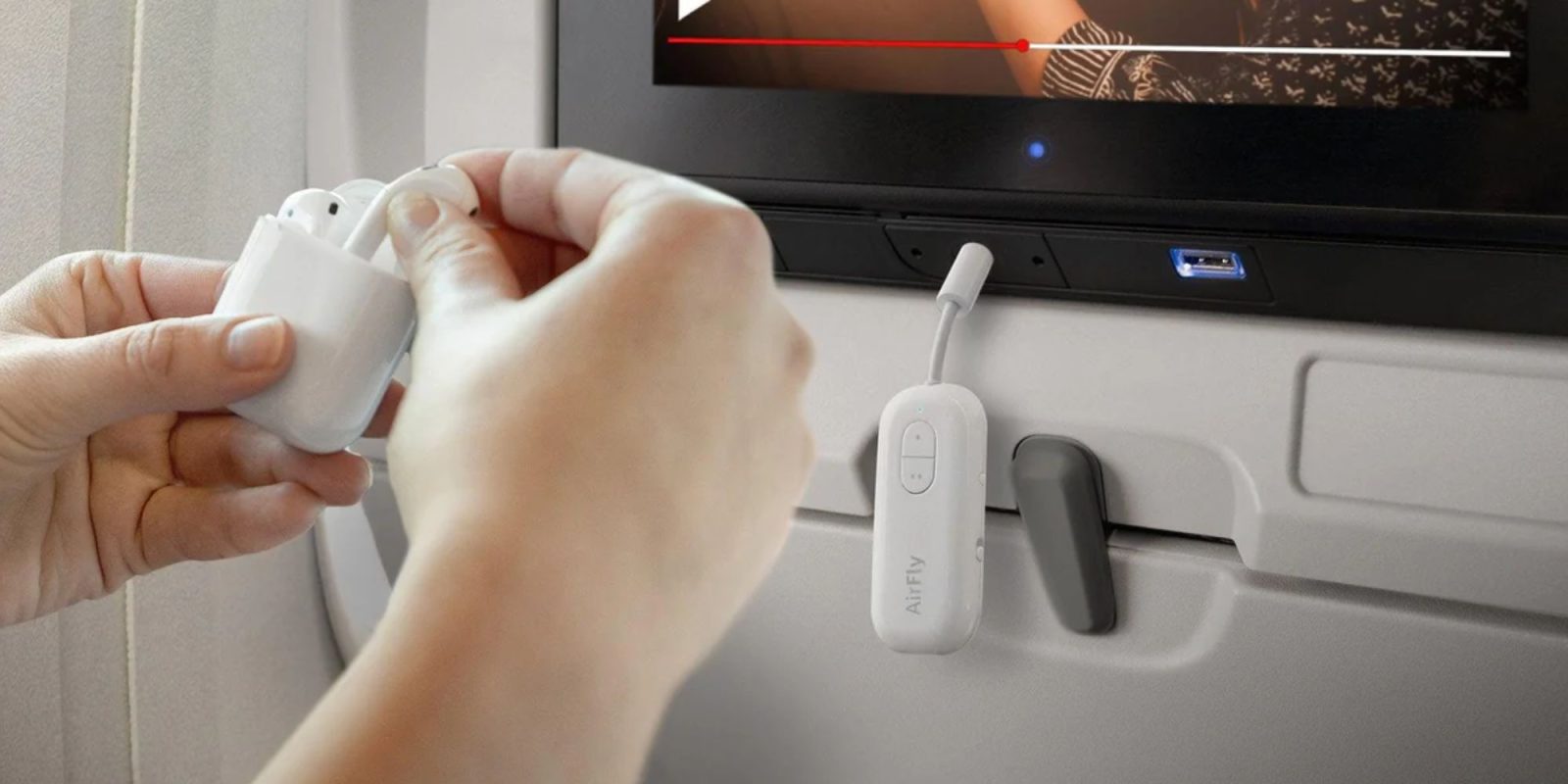 A hand holding a white earbud