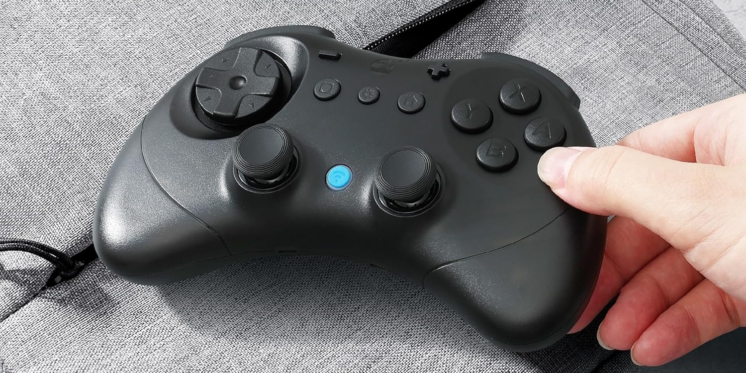 A hand holding a video game controller