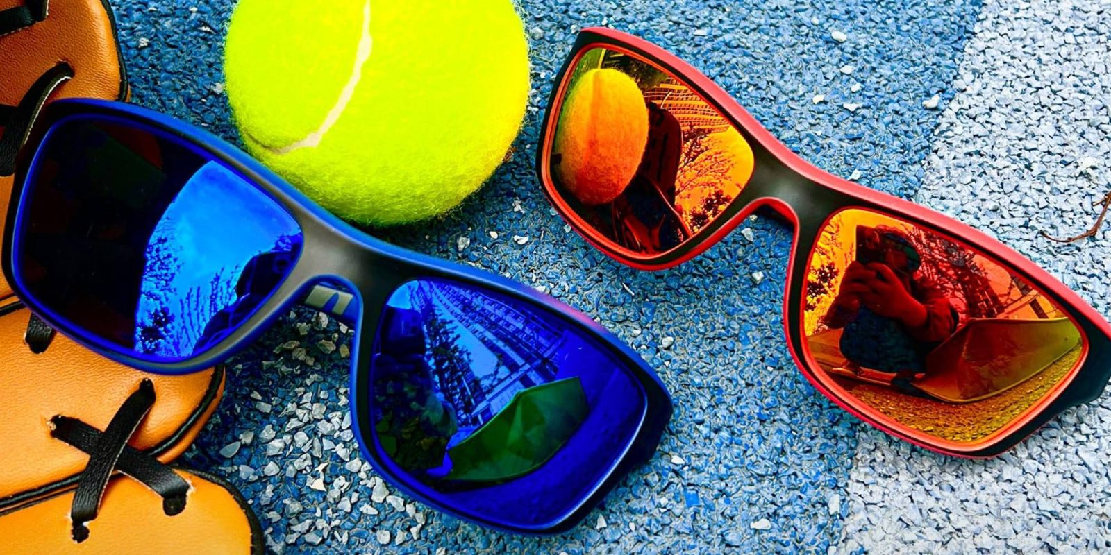 Sunglasses and a tennis ball on the ground