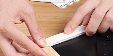 A person's hands using a white piece of paper