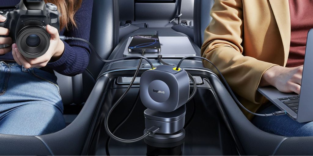 A person sitting in a car with a phone connected to a charger