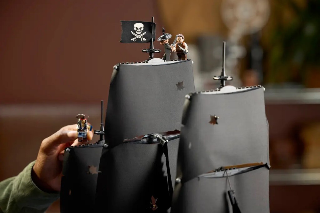 A hand holding a toy pirate ship