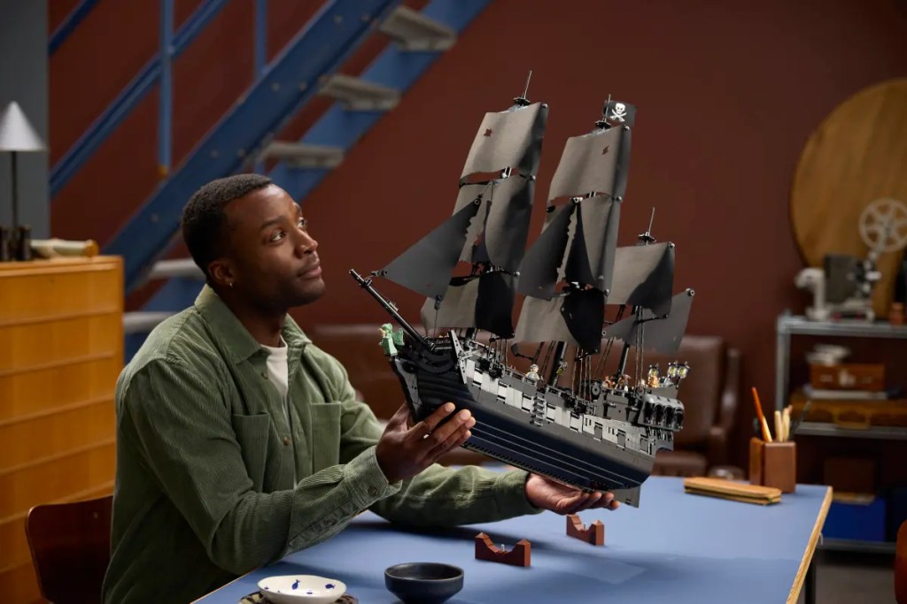 A man holding a model of a ship