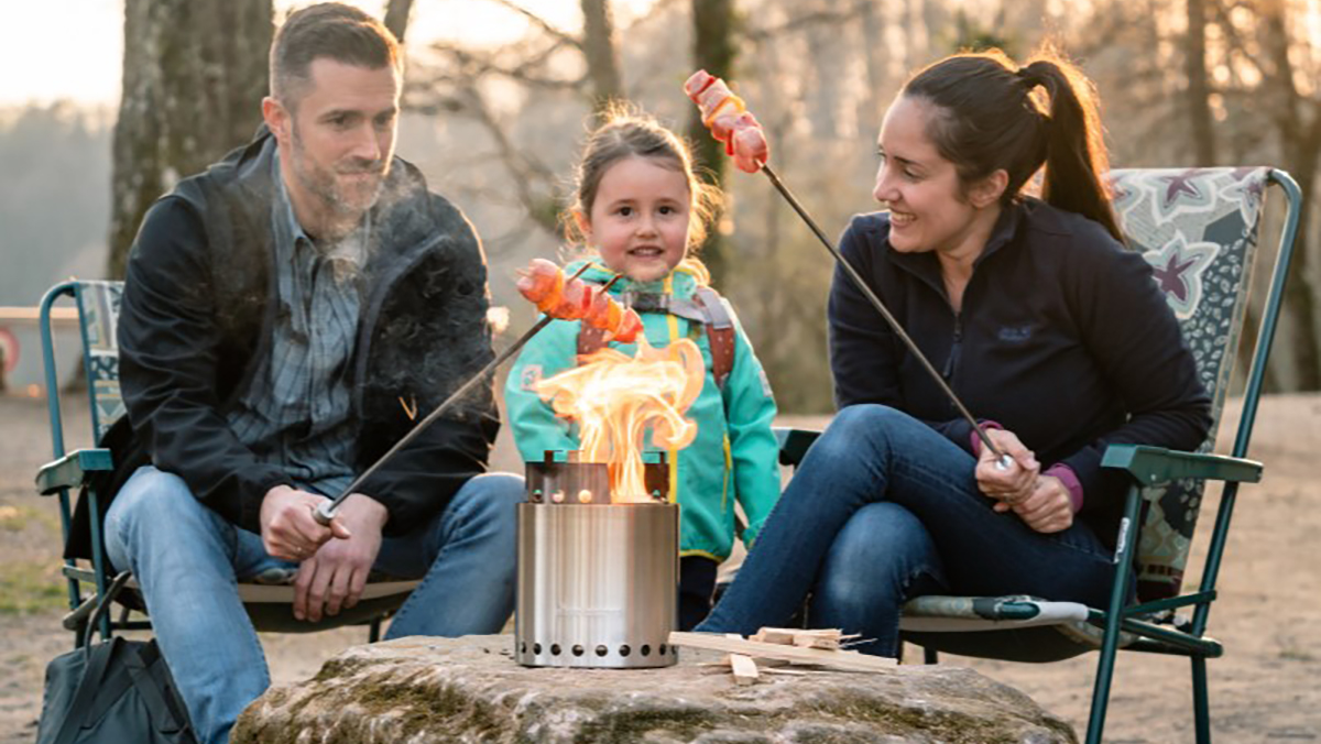 A group of people sitting around a campfire