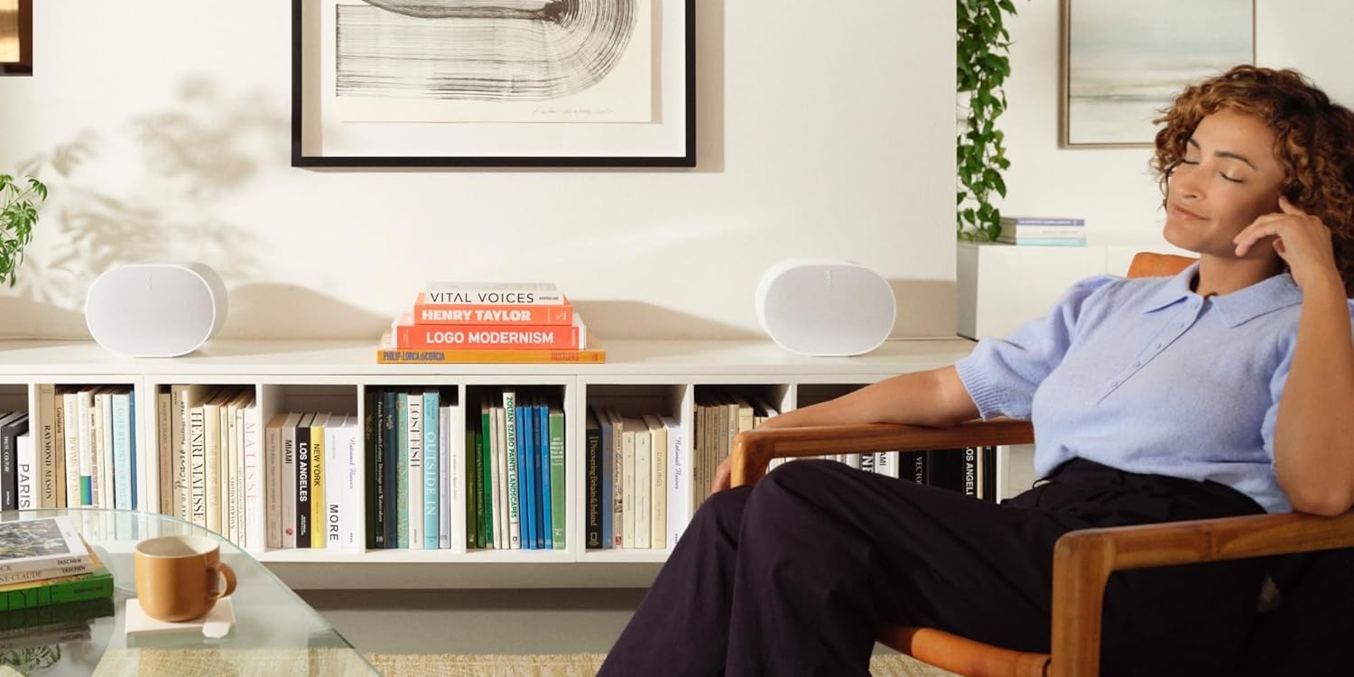 A man sitting in a chair in front of a book shelf