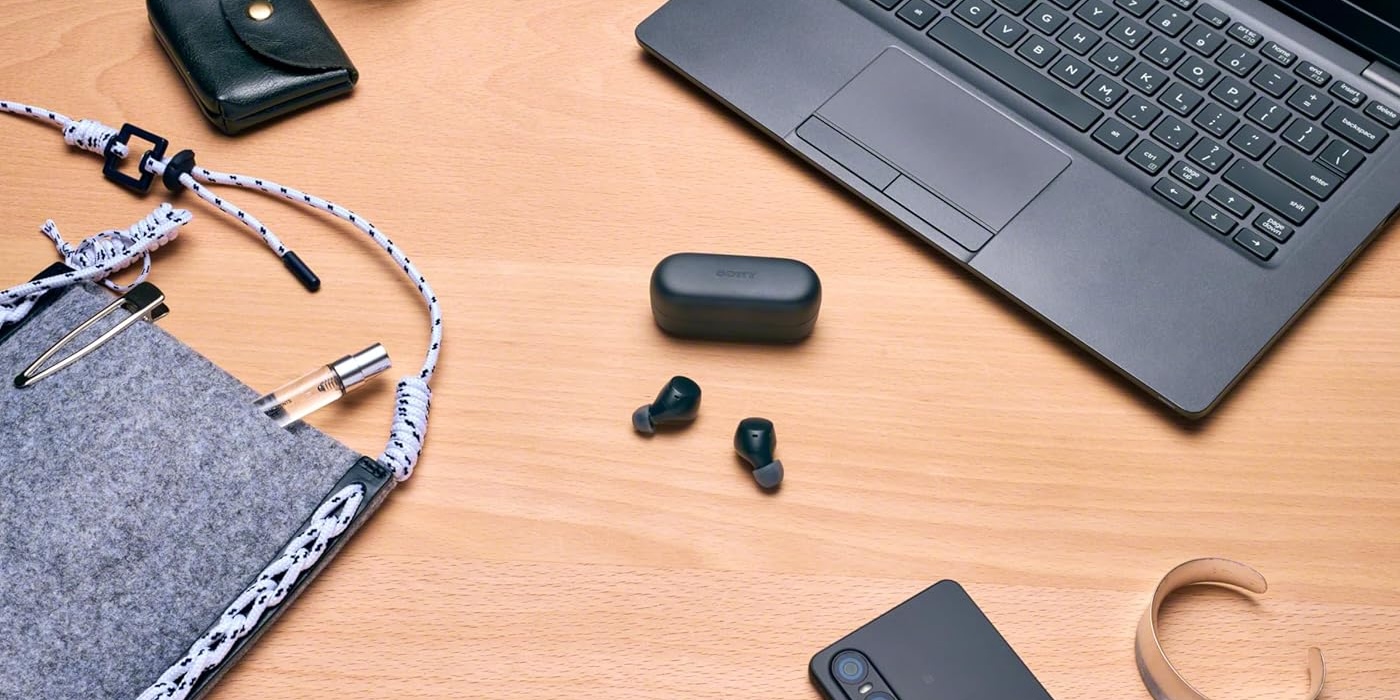 A laptop and earbuds on a table