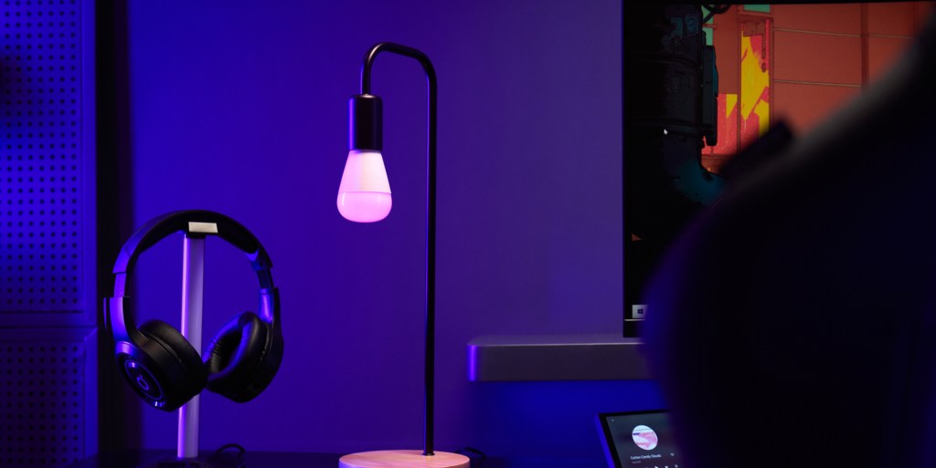 A lamp on a stand in front of a monitor