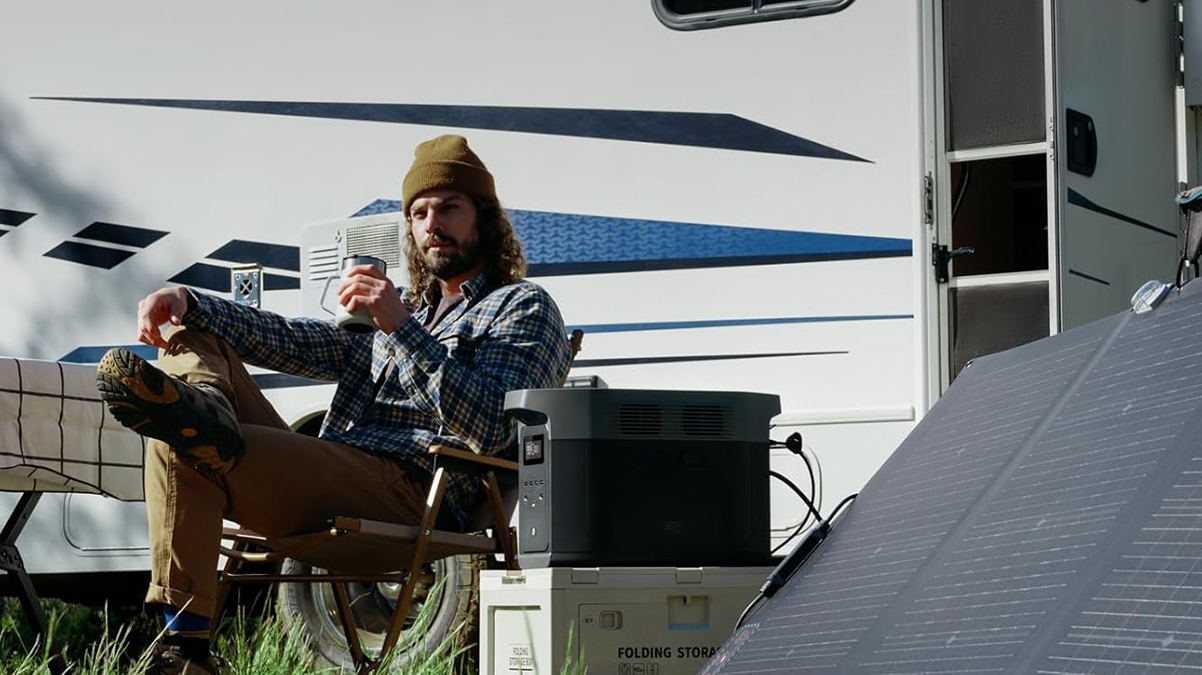 A man sitting in a chair outside of a camper
