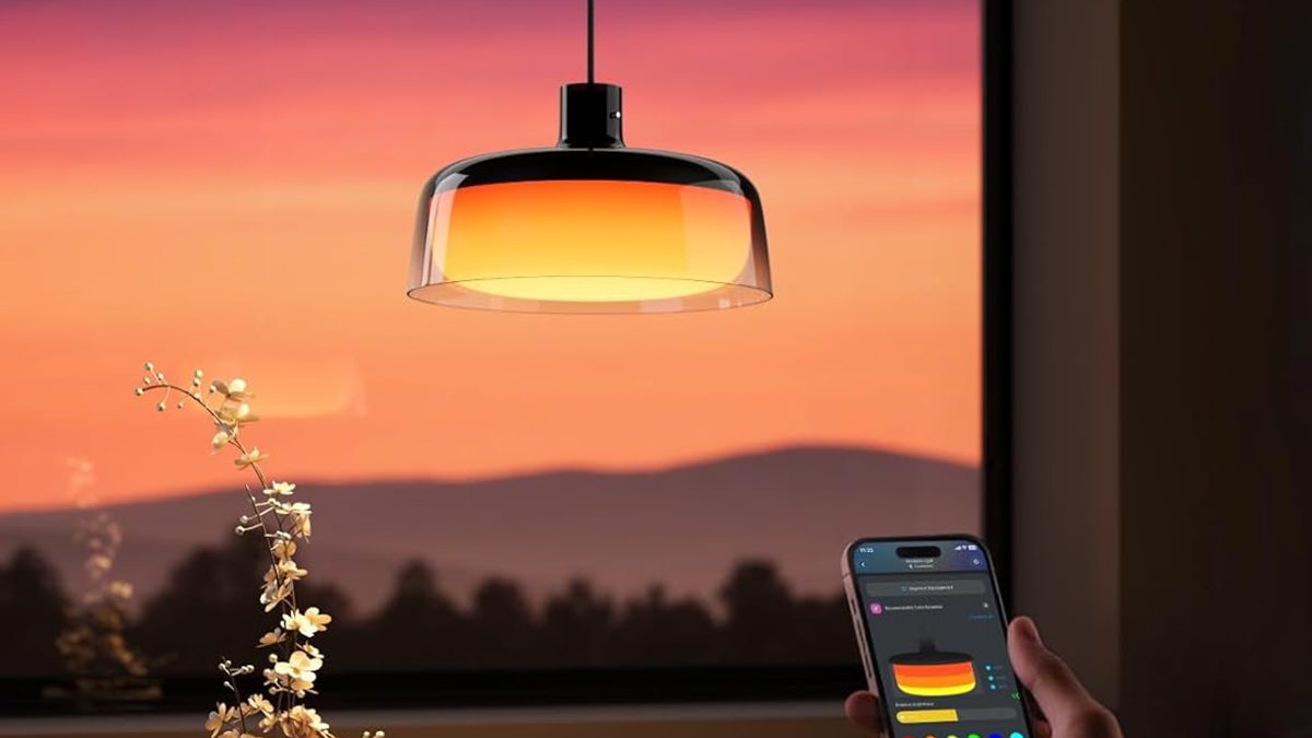 A person holding a phone with a light from the ceiling