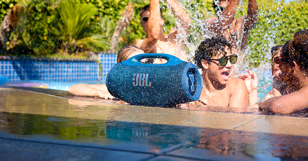 A group of people in a pool with a blue speaker