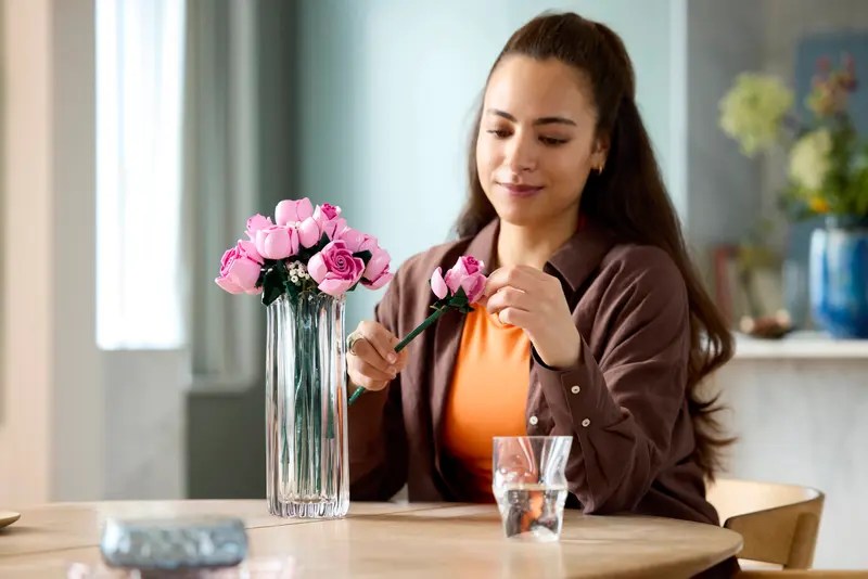 A woman arranging flowers in a vase