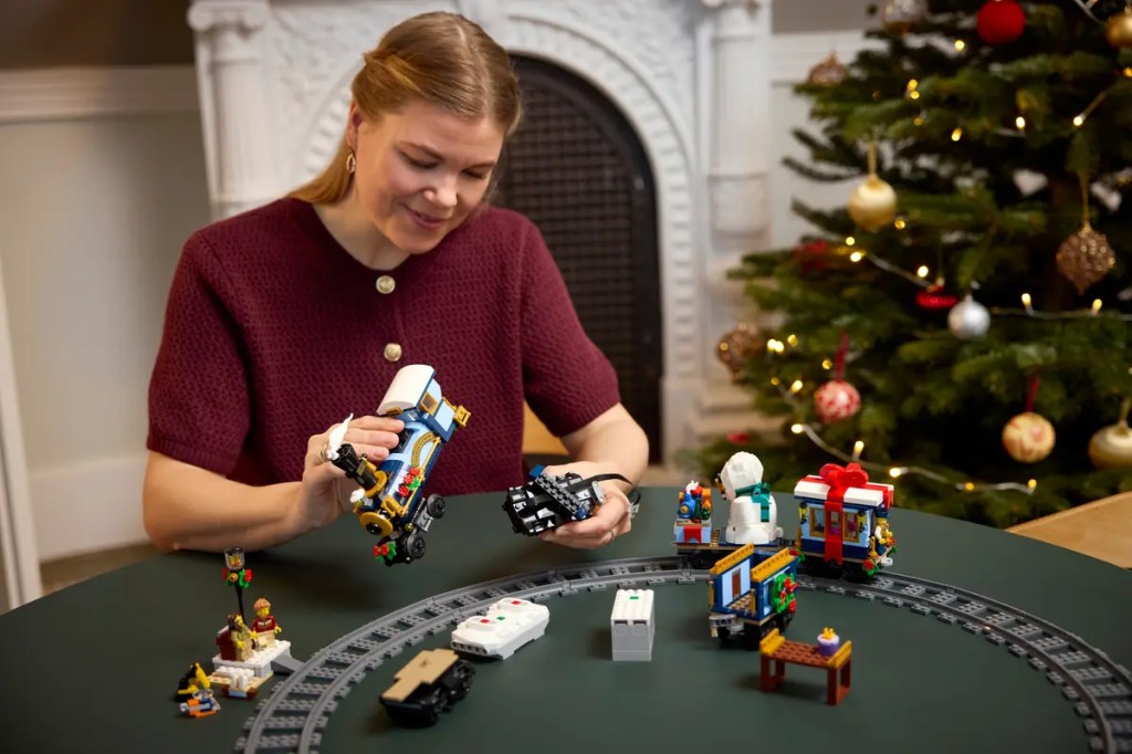 A woman playing with legos to build LEGO Winter Village set