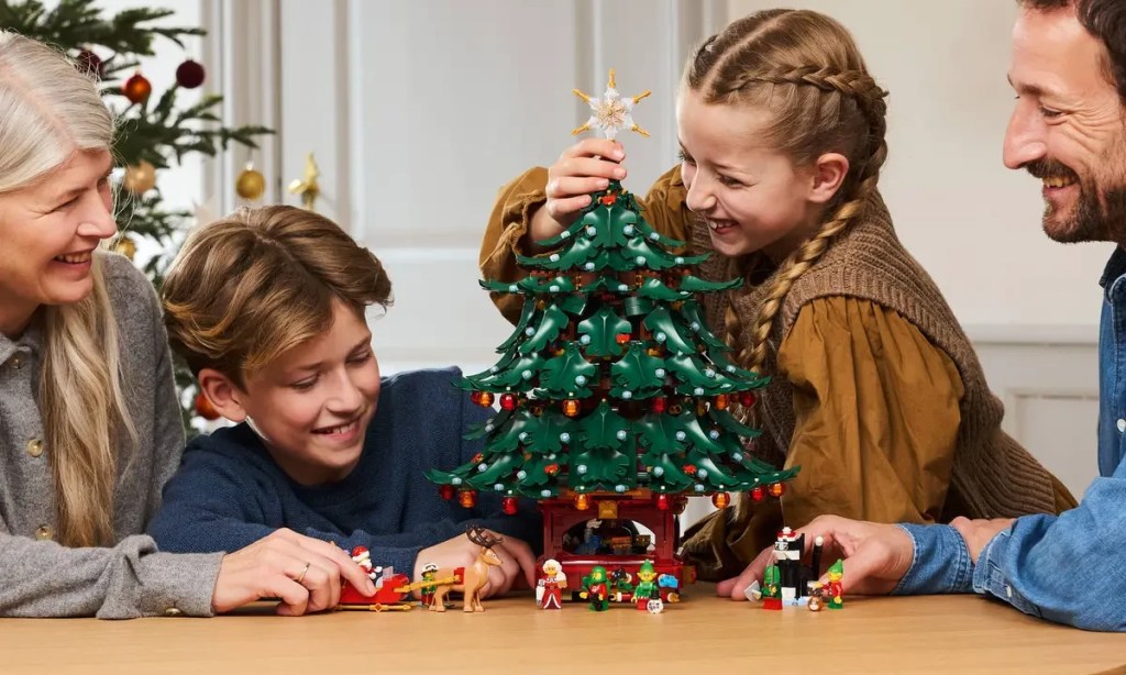 A boy and girl holding a christmas tree for LEGO Winter Village
