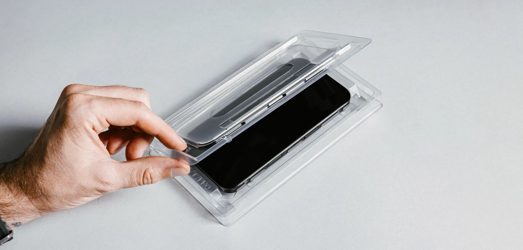 A hand holding a cell phone in a plastic case