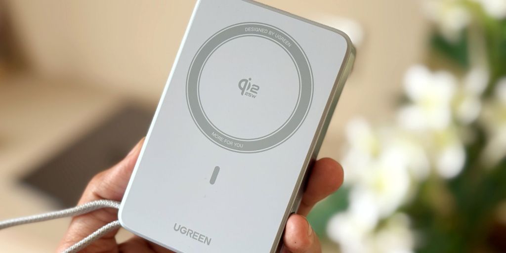 A hand holding a white rectangular device