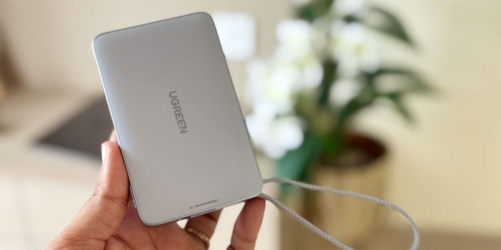 A hand holding a silver rectangular device