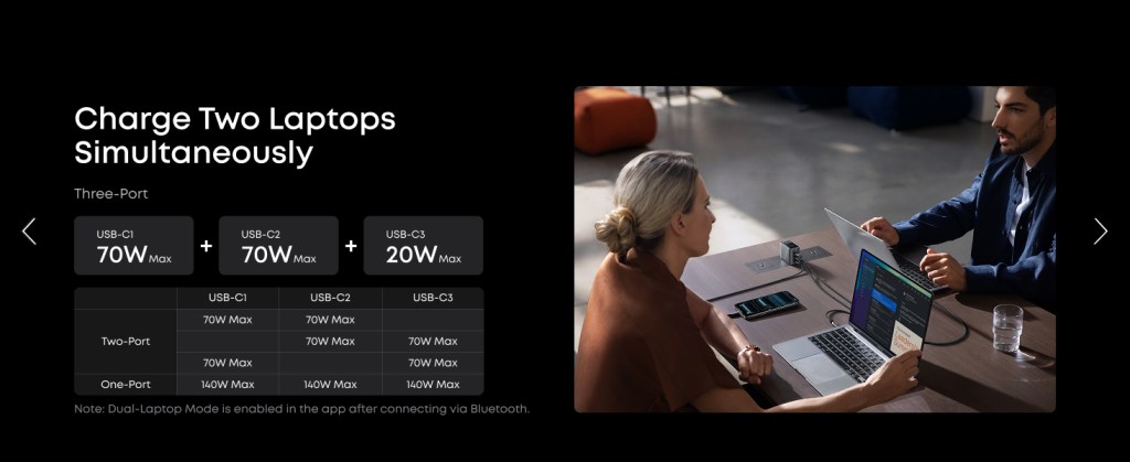 A woman sitting at a table with a phone and a laptop