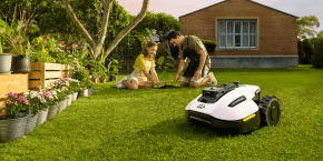 A man and a girl sitting on grass in a yard