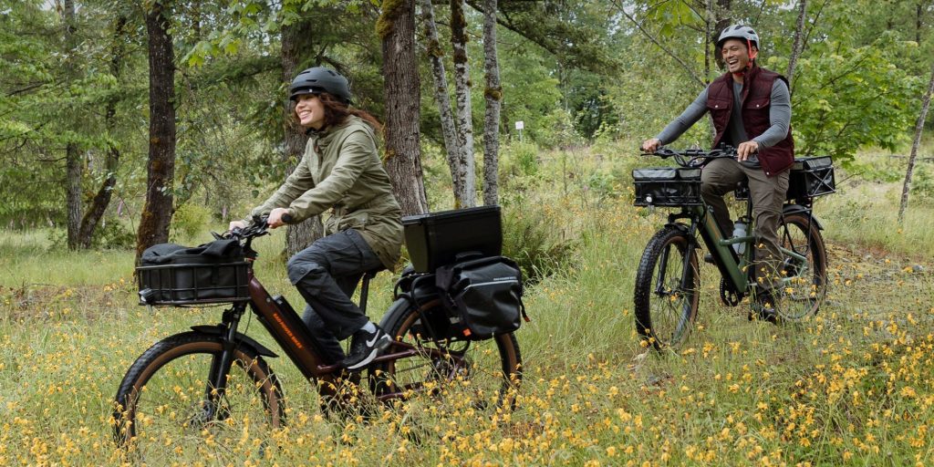 A couple of people riding bicycles in a field of flowers