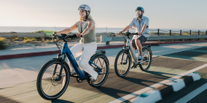 A man and woman riding bicycles on a road