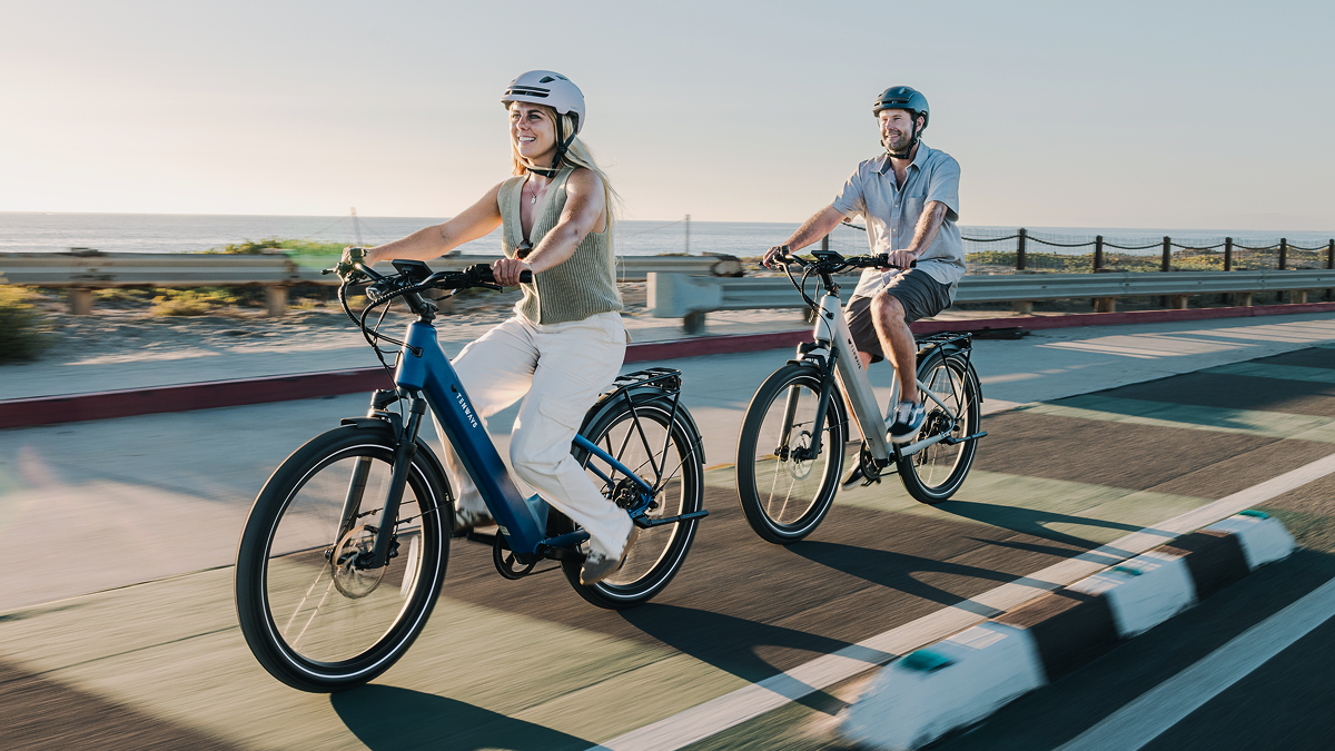 A man and woman riding bicycles on a road