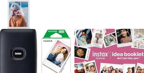 A black camera next to a box of instant photos