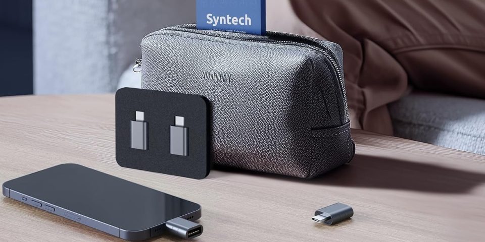 A bag with a card on top and a phone and usb cables on a table