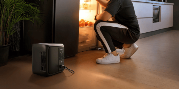 A man looking at an open refrigerator