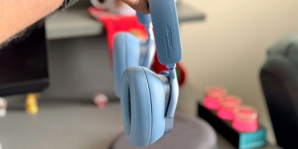 A hand holding a pair of headphones