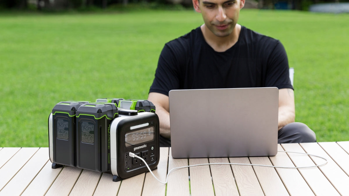 A man sitting at a table with a laptop and a portable radio