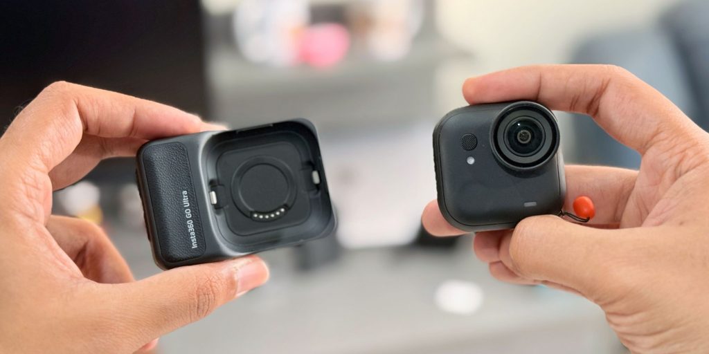 A pair of hands holding cameras