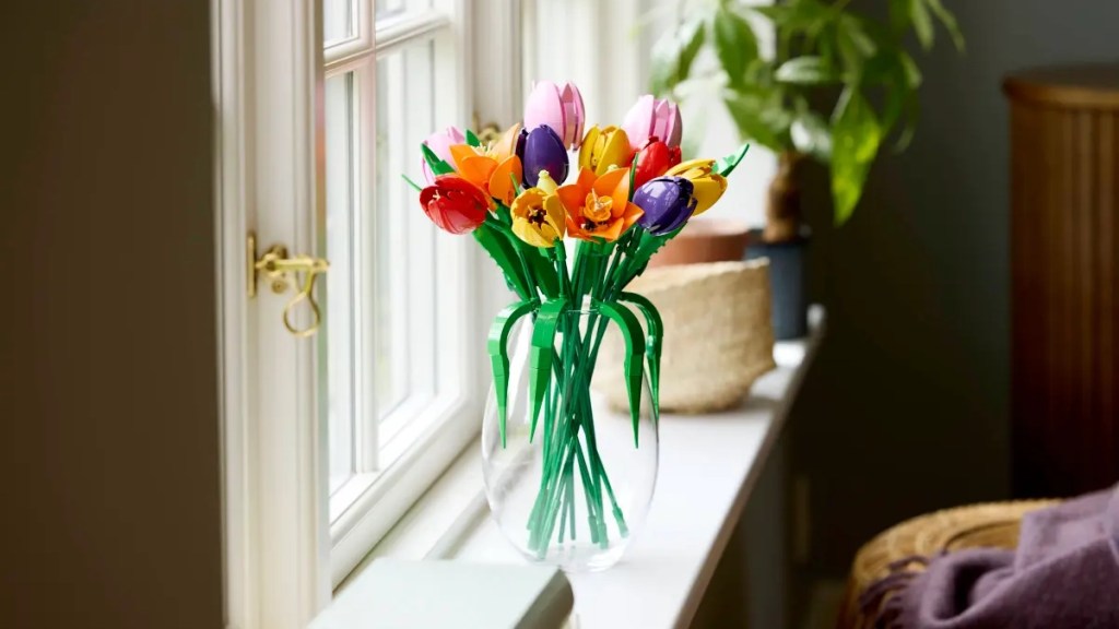 A vase of colorful tulips in a window sill