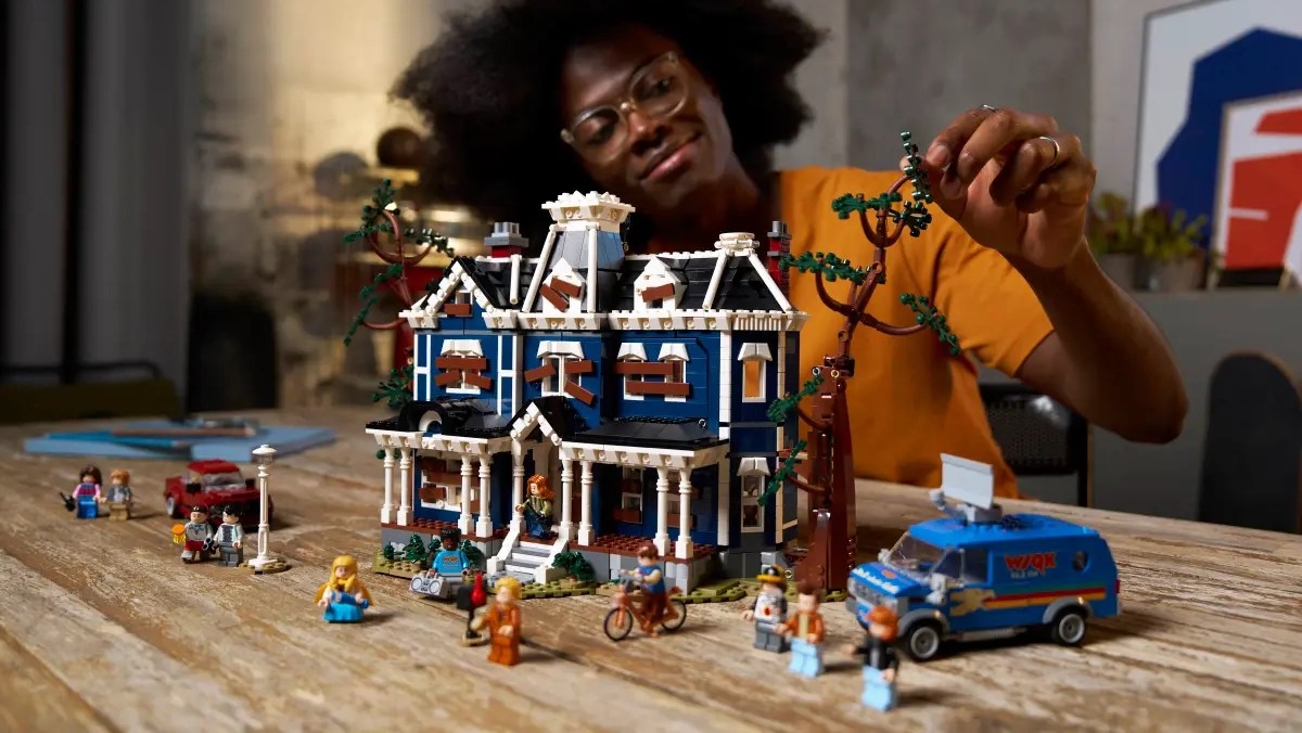 A woman playing with a toy house