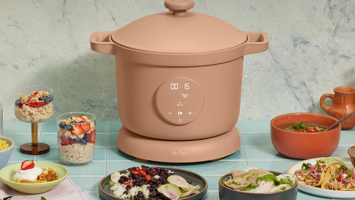 A brown slow cooker with a lid and a bowl of food on a blue tile counter
