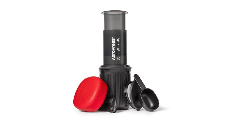A black coffee maker with a red lid