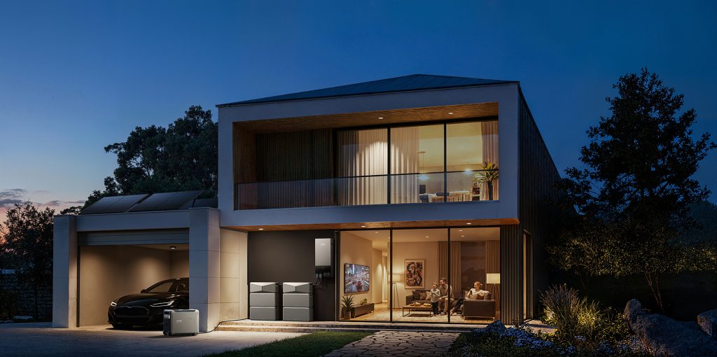 A house with glass doors and a couple of people sitting on couches