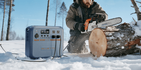 A man with a chainsaw and a log in the snow