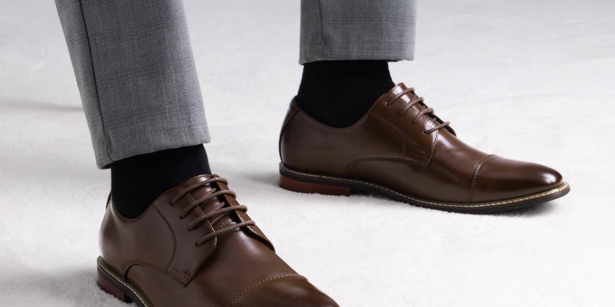 A person's feet wearing brown shoes