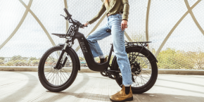 A man standing on a black bike