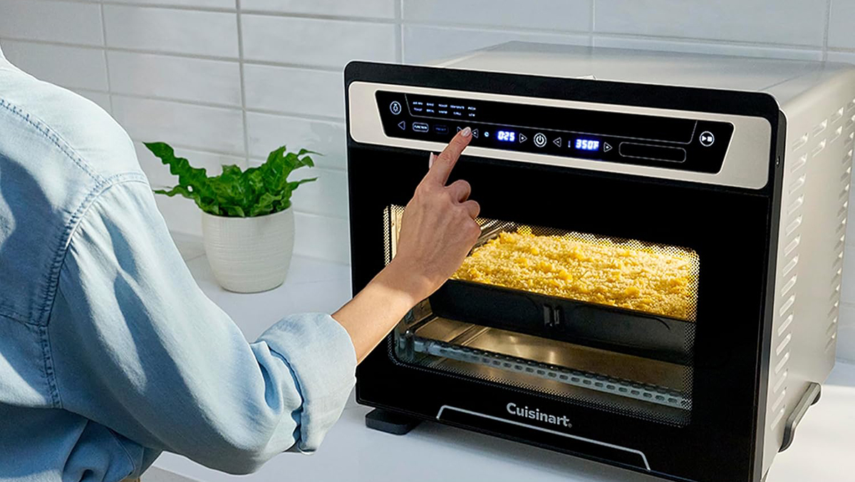 A person pointing to a food in a microwave