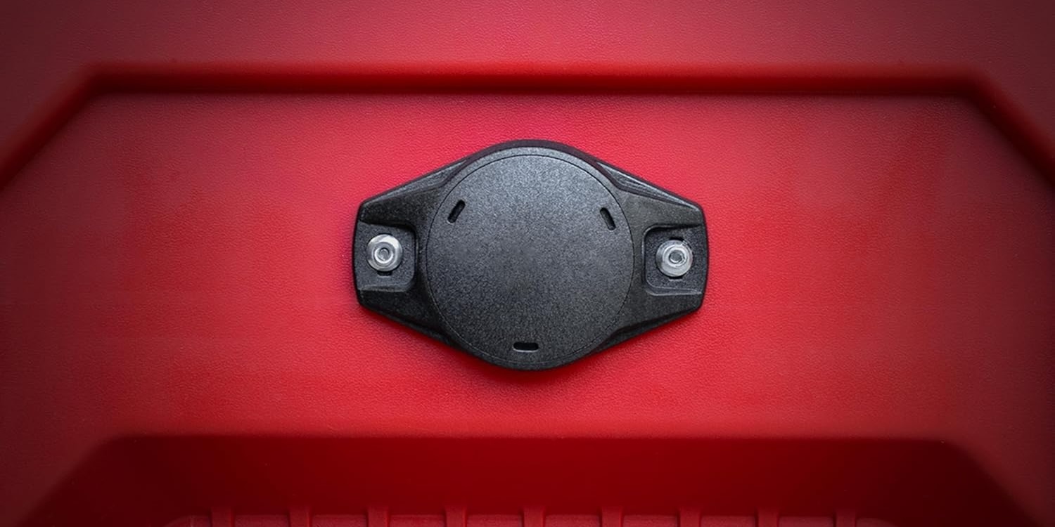 A black round object on a red plastic surface