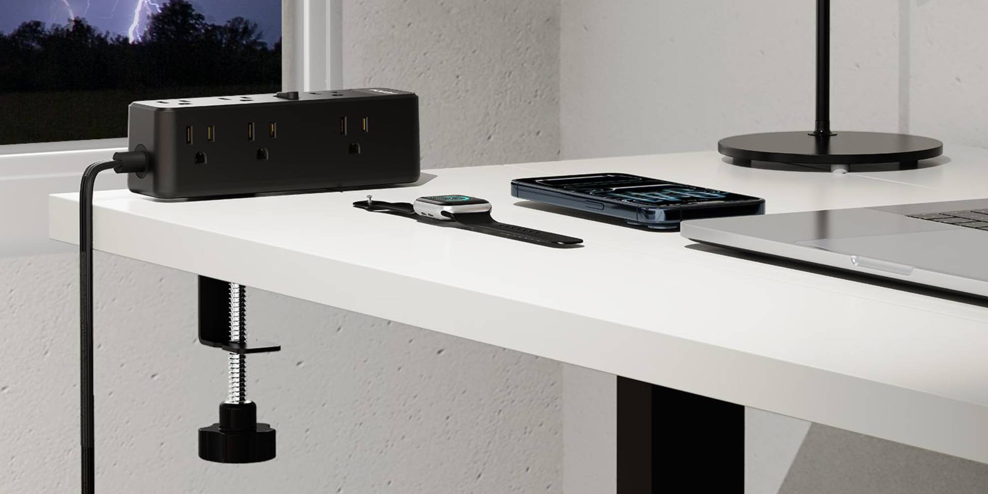 A desk with a smart watch and a laptop